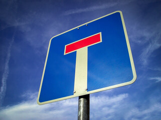 Dead end sign in front of blue sky