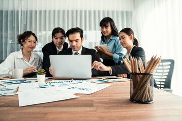 Obraz premium Focus financial data dashboard paper by business intelligence display graph, chart and statistic report on office table with blurred business people working in background. Habiliment