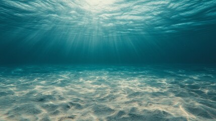 Naklejka premium Glistening rays of sunlight pierce through the crystal-clear water, illuminating the sandy ocean floor while a gentle current stirs life beneath the surface