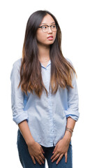Obraz premium Young asian business woman wearing glasses over isolated background smiling looking side and staring away thinking.