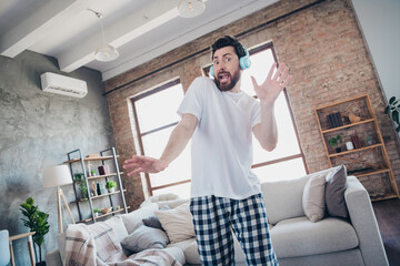 Fototapeta premium Photo of nice young man dancing headphones listen music wear pajama wake up enjoy modern cozy interior flat indoors