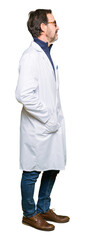 Fototapeta premium Middle age therapist wearing white coat looking to side, relax profile pose with natural face with confident smile.