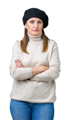 Middle age mature woman wearing winter sweater and beret over isolated background skeptic and nervous, disapproving expression on face with crossed arms. Negative person.