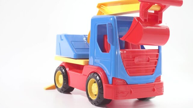 Car toy isolated on white background. Construction industrial equipment for transporting materials. Plastic child toy on white backdrop. Construction vehicle. Children's toy. Tractor Toy.