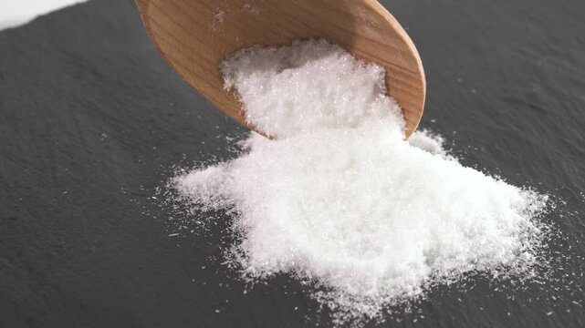 Close up of mono Monosodium glutamate (MSG)in spoon on white