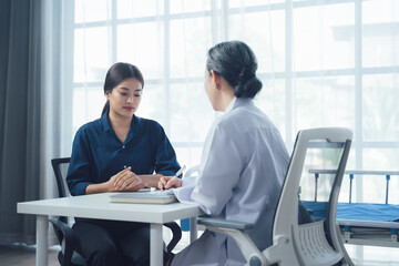 Doctor Patient Consultation:  A compassionate female doctor listens attentively to her patient...