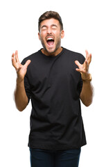 Fototapeta premium Young handsome man over isolated background crazy and mad shouting and yelling with aggressive expression and arms raised. Frustration concept.