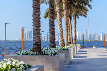 scenic waterfront promenade with the backdrop of Dubai modern skyline, featuring iconic high-rise buildings