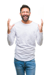 Fototapeta premium Adult hispanic man over isolated background celebrating mad and crazy for success with arms raised and closed eyes screaming excited. Winner concept