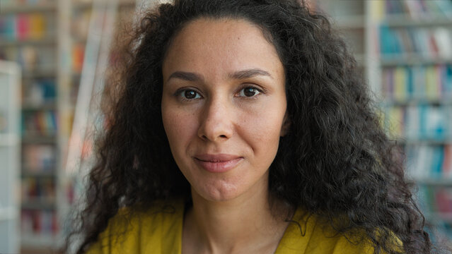 Close up Latina Caucasian Hispanic woman looking at camera portrait expression face female student high school university learning girl studying library college teacher emotion facial inside learner - Powered by Adobe