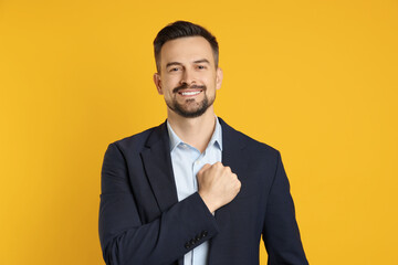Man making promise on orange background. Oath gesture