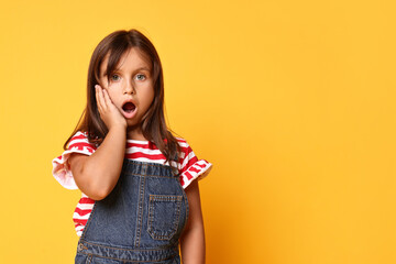 Portrait of scared little girl on orange background. Space for text