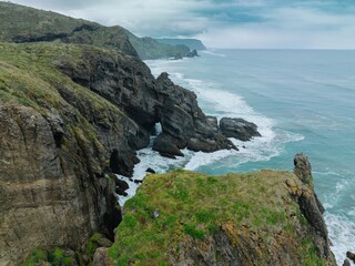 Coastal rock formations with a sea arch, waves crashing against the cliffs. Nature's artistry....