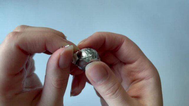 Opening a candy wrapped in aluminum foil