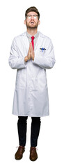 Fototapeta premium Young handsome scientist man wearing glasses begging and praying with hands together with hope expression on face very emotional and worried. Asking for forgiveness. Religion concept.