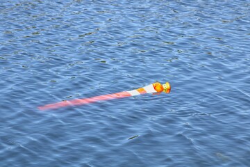 orange traffic cone floating in water