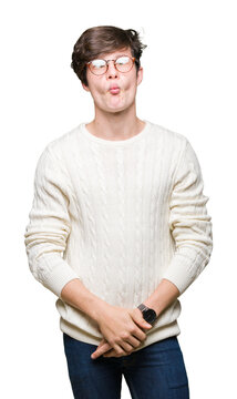 Young handsome man wearing glasses over isolated background making fish face with lips, crazy and comical gesture. Funny expression.