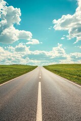 Asphalt road, green fields, blue sky, clouds.