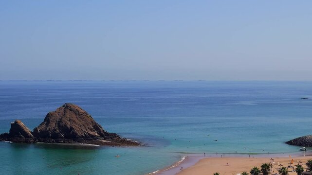Snoopy Island in Fujairah, UAE. Aerial view of the beach with turquoise waters, a rocky island and a resort nearby