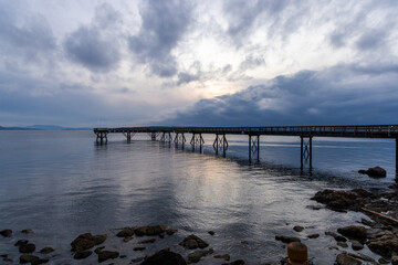 Obraz premium Scenic View of a Coastal Pier at Sunset with Tranquil Waters