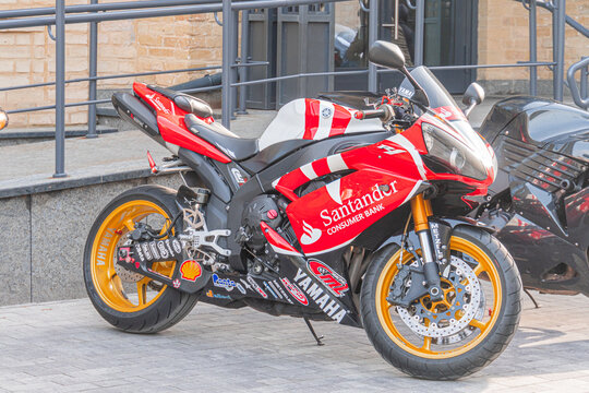 A red racing motorcycle with white and black graphics, featuring San Marino, BARBEROS, and VANS Sporty design, chrome exhaust pipe, yellow suspension or braking componen - Kyiv, Ukraine 04-20-2024