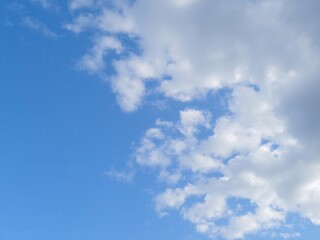 Obraz premium Fluffy white clouds drifting lazily across a clear blue summer sky, sky, fluffy, peaceful