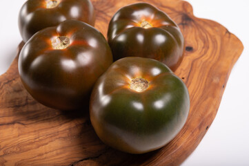 Fresh ripe sweet reddish brown and green kumato tomatoes close up