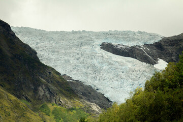 A stunning glacier stretches across the rugged mountain, its icy surface contrasting with the...