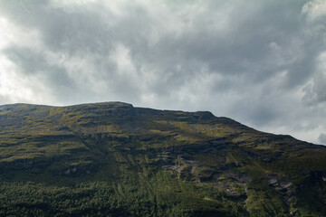 Fototapeta premium A dramatic mountain landscape under a sky filled with intense, swirling clouds.