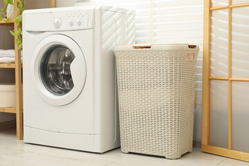 Wicker laundry basket and washing machine in bathroom
