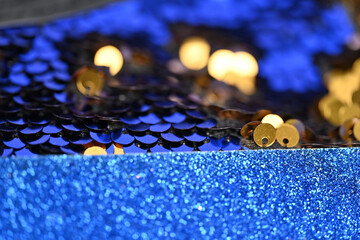 Golden and Blue Glitter Fusion: A Captivating Macro Shot of Sparkling Sequins and Glittery Textures, Highlighting the Contrast Between Warm Golden Tones and Vibrant Blue Hues for a Stunning Abstract D