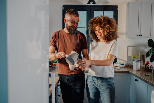 Happy couple enjoying morning coffee ritual in kitchen