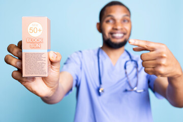 Portrait of doctor recommends using high protection sunscreen products, talking about importance of...