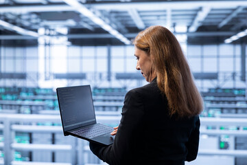 Technician in data center checking rigs and hardware, doing maintenance. IT specialist planning and...