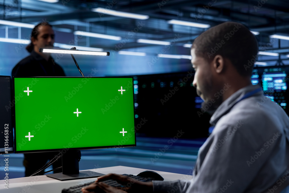 Poster employee using green screen pc to check for signs of imminent failure in data center supercomputers.