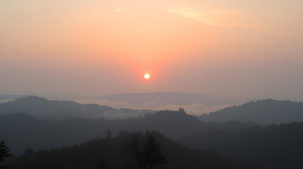 Obraz premium Serene sunrise over a misty mountain range