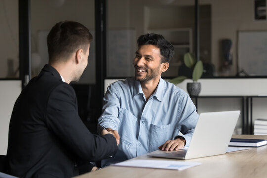 Business partners shaking hands as successful conclusion of meeting or negotiations in office, sign contract, sell and buy company services, showing mutual respect, trust, satisfaction with outcome