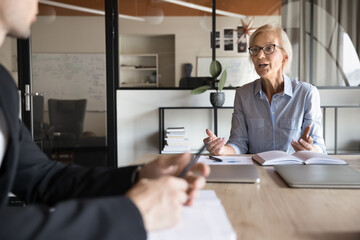Mature 55s businesslady hold formal meeting with company clients, gathered together at conference...