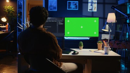 Self employed man doing IT support job from apartment personal office, coding on green screen PC....