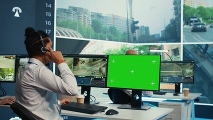 Indian operator monitors traffic next to a greenscreen on display, following surveillance footage...