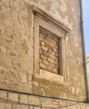 Korcula, Croatia - June 30, 2024: Closeup, Ancient window filled with bricks at Kanavelic Tower