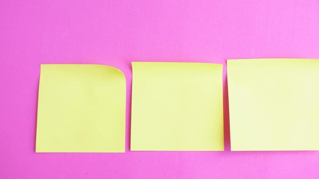 Row of three yellow sticky notes on a pink background