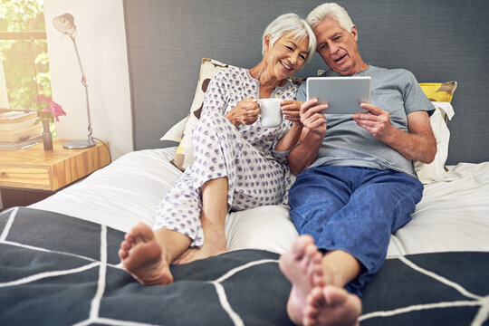 Senior couple, tablet and happy for watching, online and relax in retirement as pensioner in bedroom. Elderly people, smile and partners on technology for connection, communication or bonding in home