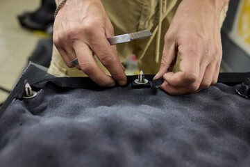Hands Engaging in the Detailed Work on a Textured Material Essential for Manufacturing