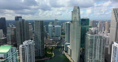 Luxury yachts sailing on Miami River in downtown district of Miami Brickell in Florida, USA. Urban skyline with high skyscraper buildings in modern American megapolis.