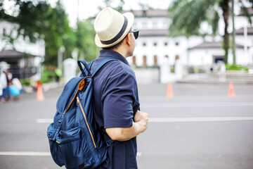 Rear View of Excited Traveler Man Standing on Sidewalk While looking Around