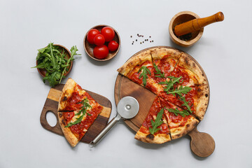 Composition with tasty pizza, ingredients and cutter on grey background