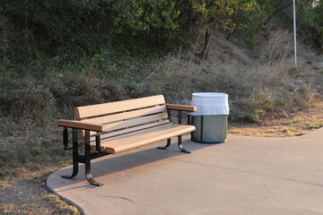 Bench in Park Next to a Trash Can