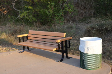 Bench in Park Next to a Trash Can