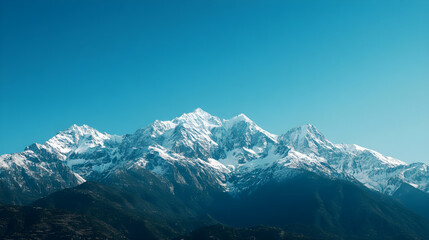 Fototapeta premium Snow-capped mountains under a clear blue sky, winter weather, cold and majestic